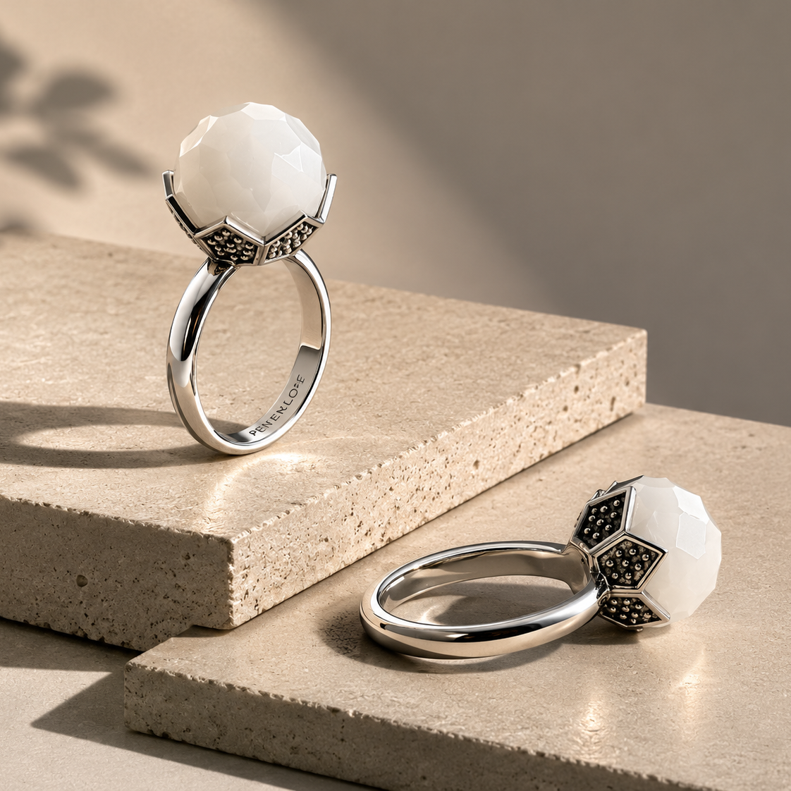 Dy pamje te unazes Luna U3178 prej celiku inox me agat te bardhe te facetuar: nje ne kembe dhe nje e shtrire mbi blloqe bezhe | Penelope Jewellery