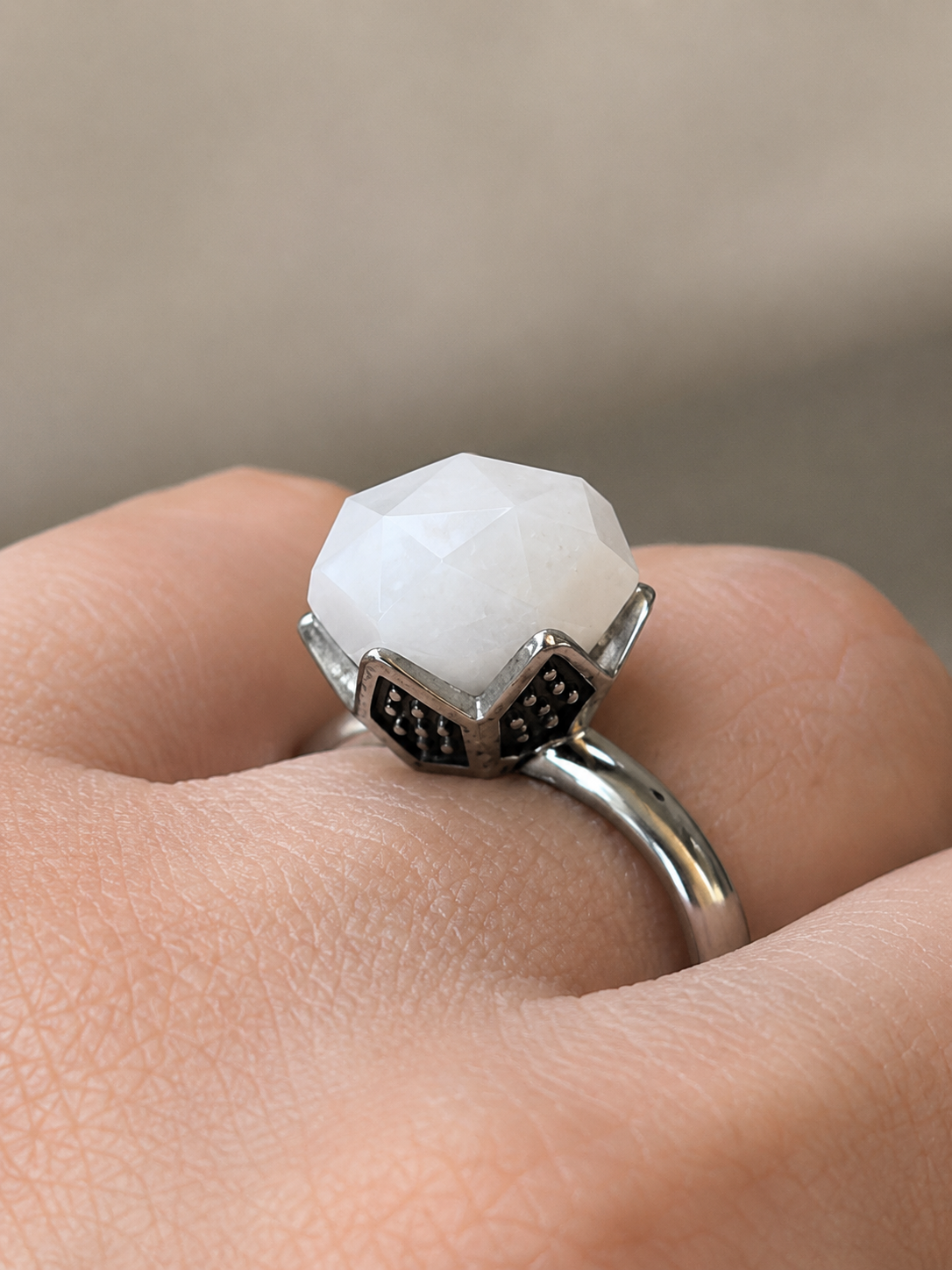 Unaze Luna U3178 prej celiku inox me agat te bardhe te facetuar dhe montim dekorativ si kurore, detaj nga afer e veshur ne gisht | Penelope Jewellery