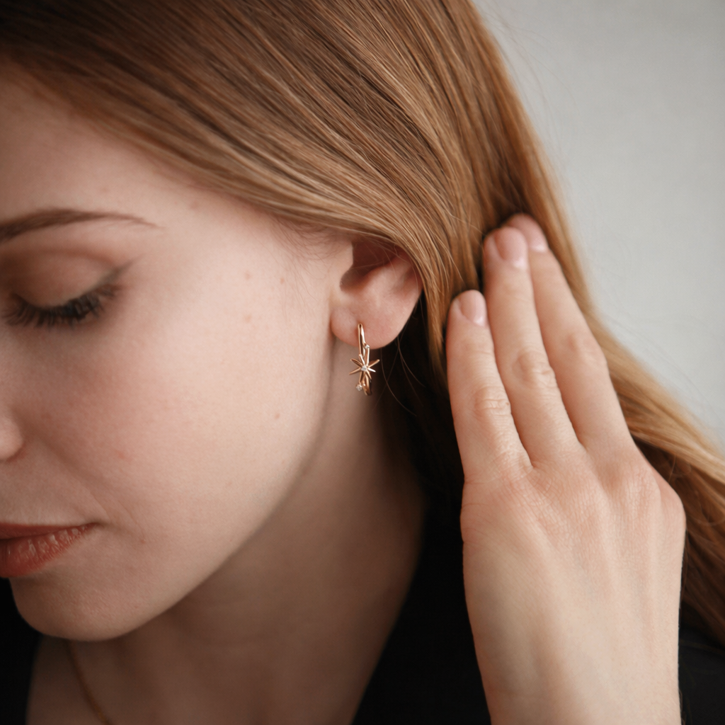 Vath Cosmic Star V6065 prej argjendi 925 me veshje ari 14K dhe motive yjesh, pamje e afert ne vesh me doren prane flokeve | Penelope Jewellery