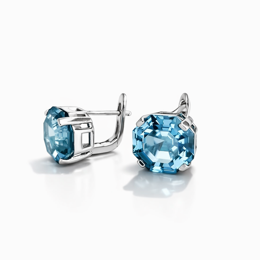 Cift vathesh ngjyre argjendi me gure blu te fasetuar, katrore me qoshe te prera, njeri perballe dhe tjetri anash, ne sfond te bardhe | Penelope Jewellery