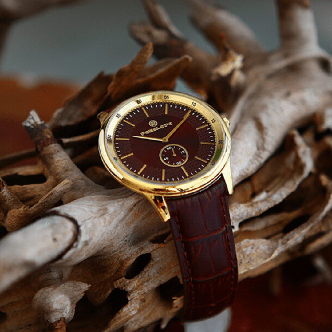 Gold-tone wristwatch with brown dial and leather strap, elegant analog men's accessory